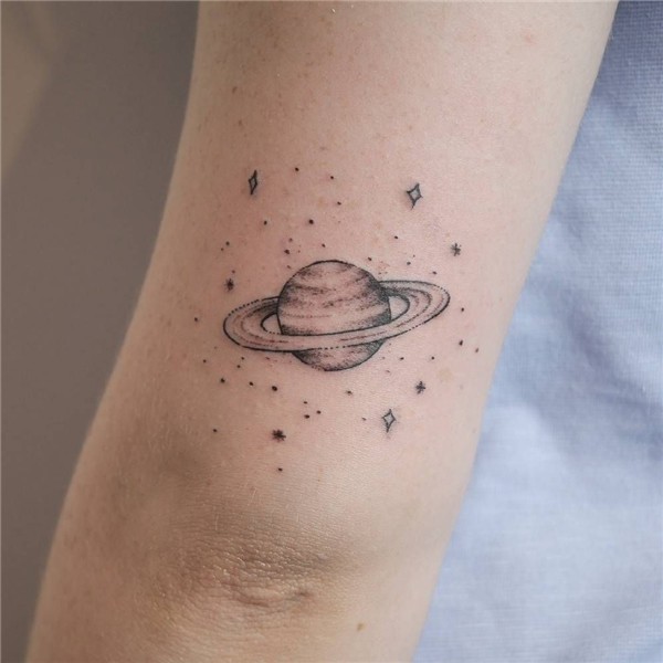 A small Saturn tattooed on the back of the left upper arm by