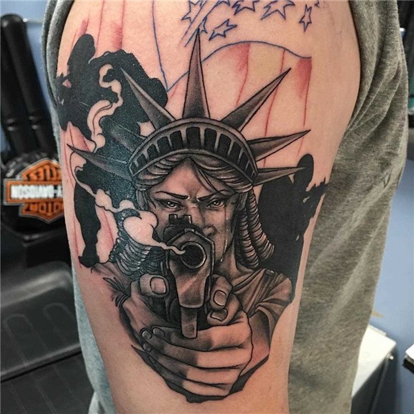 ✔ A tatuagem da estátua da liberdade com uma arma no ombro d