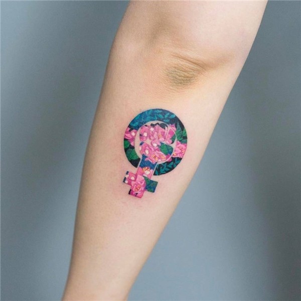Feminist symbol tattoo on the left forearm.