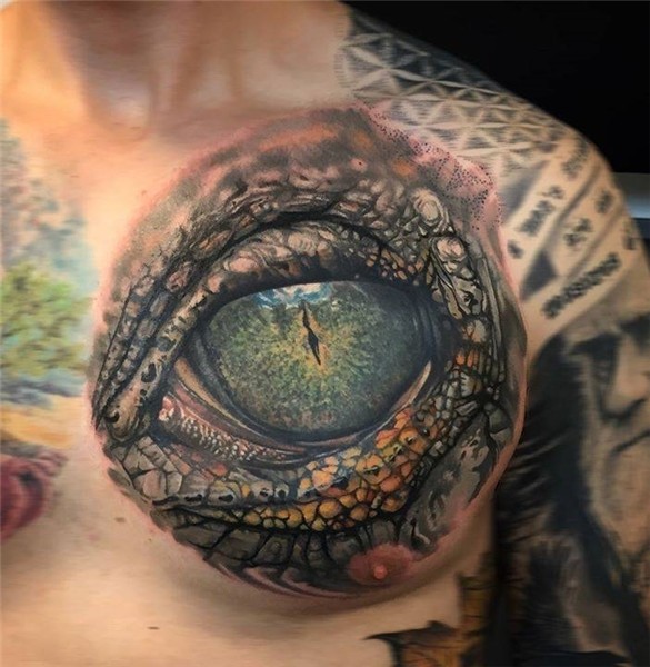 Reptile eye tattoo on the left side of the chest.