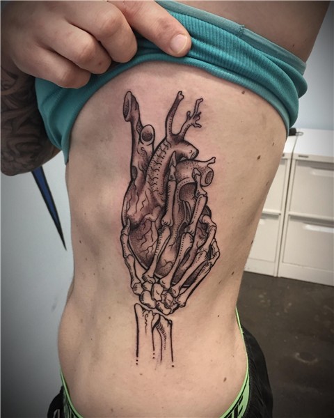 Skeleton hand holding a human heart. Done by Stephanie Amate