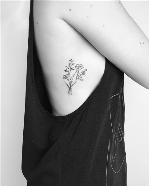 Small minimalist wildflower tattoo with fine black lines and